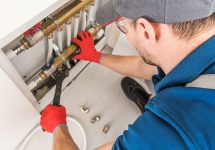 plumbing-system-fix-job-2021-08-26-23-04-54-utc Plumbing System Fix Job. Caucasian Technician Looking For Potential Issue Inside Residential Central Heating System.